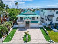 Two-story waterfront home with a large driveway and green lawn at 833 Bay Point Dr, Madeira Beach, FL 33708