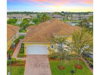 Charming yellow home with a tile roof, brick driveway, and attached two car garage at 4737 Casswell Dr, New Port Richey, FL 34652