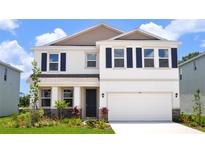 Charming two-story home with a well-manicured lawn and a two-car garage with classic navy blue shutters at 708 160Th E Ln, Bradenton, FL 34212