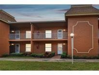 Two-story building, featuring multiple units with balconies and well-maintained landscaping at 12760 Indian Rocks Rd # 910, Largo, FL 33774