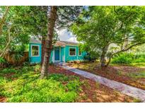 Quaint teal house with lush landscaping and a walkway at 2219 Beach S Blvd, Gulfport, FL 33707