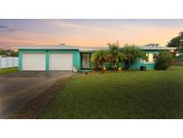 Charming teal house with two-car garage and well-manicured lawn at 1954 Elliott Dr, Clearwater, FL 33763