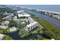 Aerial view of a condo building in a waterfront community with a pool and surrounding buildings at 11590 Shipwatch Dr # 548, Largo, FL 33774