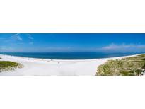 Panoramic view of a wide sandy beach with gentle waves under a bright blue sky at 15 Somerset St # 6A, Clearwater Beach, FL 33767