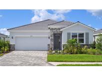 Charming one-story home with a stone facade, a two-car garage, and a well-manicured front yard at 18208 Beach Ranch Ter, Lakewood Ranch, FL 34211