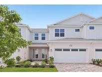 Charming two-story townhouse with a two-car garage, landscaped yard, and covered entryway at 31907 Anchor Point Dr, Wesley Chapel, FL 33545