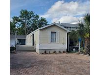Charming single-story home with a brick driveway and small front yard, offering a cozy curb appeal at 21027 Lazy Days Cir, Lutz, FL 33558
