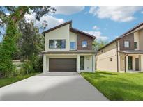 Modern two-story house with a two-car garage and well-manicured lawn at 12300 Land St, Largo, FL 33773