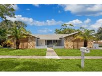 Ranch style home with stone and wood accents at 1921 Blue Heron Way, Palm Harbor, FL 34683