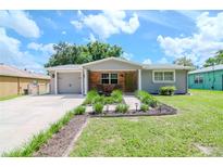 Charming renovated home with a landscaped front yard and attached garage at 9717 N Rome Ave, Tampa, FL 33612