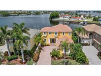 Stunning waterfront home featuring vibrant color, lush landscaping, and private boat dock at 1233 Acappella Ln, Apollo Beach, FL 33572
