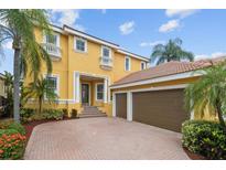 Elegant home featuring a spacious driveway and a three-car garage at 1233 Acappella Ln, Apollo Beach, FL 33572