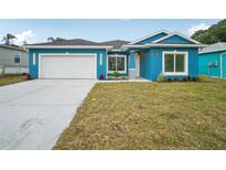 Charming blue single-Gathering home featuring a well-manicured lawn and a two-car garage at 272 Diogenes St, Dunedin, FL 34698