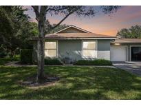 Single-story home with attached garage and lush landscaping at 251 Hidden Brook Dr # 102C, Palm Harbor, FL 34683