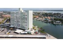 Aerial view of a waterfront high-rise building with parking and a pool at 31 Island Way # 502, Clearwater Beach, FL 33767