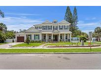 Beautiful two-story home featuring white brick, a covered porch with columns, and lush landscaping at 4536 W Swann Ave, Tampa, FL 33629