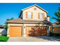 Two-story house with two-car garage and landscaped lawn at 14211 Edinburgh Moor Dr, Wimauma, FL 33598