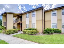 Tan building exterior with landscaping and a staircase at 10100 Sailwinds N Blvd # 205, Largo, FL 33773