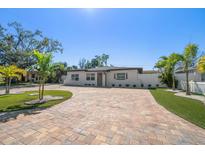 Charming single story home with brick driveway, manicured lawn and beautiful landscaping at 6750 W Flamingo S Way, St Petersburg, FL 33707