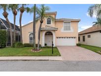 Two-story home with a peach-colored exterior and a brick driveway at 10713 Cape Hatteras Dr, Tampa, FL 33615