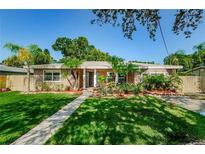 Attractive ranch home with landscaped lawn and walkway at 705 Bayshore Dr, Tarpon Springs, FL 34689