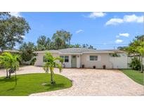 Attractive single-story home with palm trees and brick driveway at 6750 W Flamingo S Way, St Petersburg, FL 33707