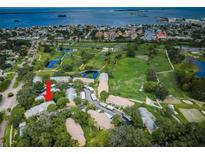 Stunning aerial view of community with lush landscaping, golf course, and water views at 2156 Masters Ct # 2156, Dunedin, FL 34698