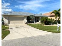 Single-story house with a metal roof, and landscaped yard at 132 Peckham Se St, Port Charlotte, FL 33952