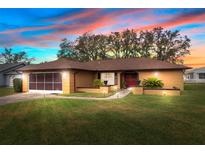 Single-story house with a brown roof and lush lawn at 8227 Rhanbuoy Rd, Spring Hill, FL 34606