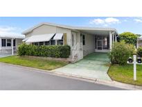 Charming home with a covered carport, mature landscaping, and decorative window awnings at 12501 Ulmerton Rd # 131, Largo, FL 33774