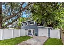 Charming two-story home with a well-manicured lawn and a white fence at 733 1/2 New Jersey St, Clearwater, FL 33756