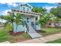 Charming two-story home with a light blue exterior and a welcoming front porch at 222 Hope St, Tarpon Springs, FL 34689