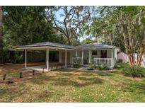 Charming single story home featuring a covered front porch and carport, set amongst mature landscaping at 12318 Woodleigh Ave, Tampa, FL 33612