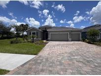 Single-story home featuring a spacious driveway, well-maintained lawn, and a 2-car garage, under a bright blue sky at 4303 Pullet Ct, Lakewood Ranch, FL 34211