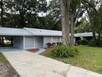 Newly painted house with a carport and well-maintained lawn at 504 Maydell Dr, Tampa, FL 33619