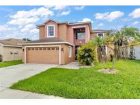 Two-story house with a two-car garage and landscaped lawn at 11302 Southwind Lake Dr, Gibsonton, FL 33534
