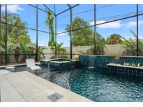 Inviting screened pool area with waterfall feature, spa, and lush tropical landscaping at 2600 Quincy S St, Gulfport, FL 33711