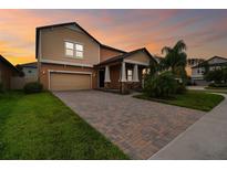 Charming two-story home featuring a brick driveway, well-manicured lawn, and inviting front porch at 11464 Chilly Water Ct, Riverview, FL 33569