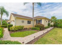 Exterior view of a yellow house with a landscaped yard at 1908 Sterling Glen Ct, Sun City Center, FL 33573