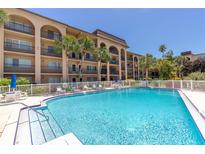 Community pool with surrounding patio furniture at 2525 W Bay Dr # D41, Belleair Bluffs, FL 33770