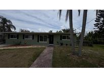 Charming single-story home with a well-maintained lawn and a brick walkway leading to the front door at 5805 Oxford Dr, Tampa, FL 33615