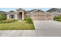 Two-story home with landscaped yard and two-car garage at 5608 Madrigal Way, Apollo Beach, FL 33572
