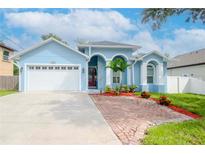 Light blue house with a brick driveway and well-manicured lawn at 803 W Sligh Ave, Tampa, FL 33604