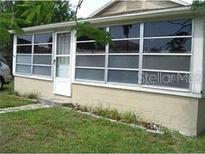 Cozy home with a sunroom and well-maintained lawn at 18005 1St E St, Redington Shores, FL 33708