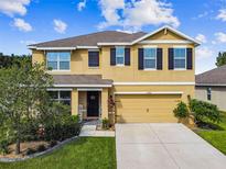Two-story house with a two-car garage and landscaping at 35744 Jenny Lynne Cir, Zephyrhills, FL 33541
