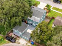 Expansive aerial view of a two-story home with a spacious yard, mature trees, and modern exterior paint at 6619 Livingston N Ave, St Petersburg, FL 33702