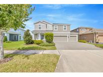 Charming two-story home with a manicured lawn, complemented by a two car garage and beautiful landscaping at 16462 Courtyard Loop, Land O Lakes, FL 34638