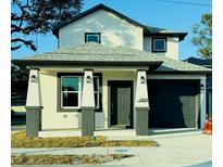 Two-story house with dark gray roof, and dark green door at 2404 E Chelsea, Tampa, FL 33610