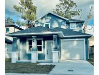 Two-story house with gray siding, a gray roof, and a white door at 4403 N 24Th, Tampa, FL 33610