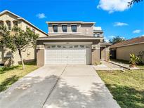 Two-story house with a white garage door and landscaping at 6324 Cherry Blossom Trl, Gibsonton, FL 33534